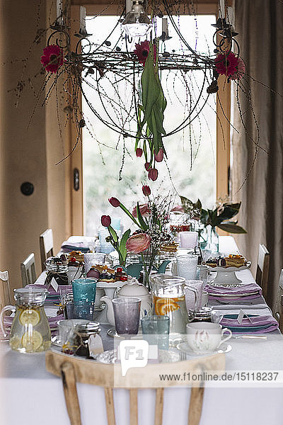 Gedeckter Tisch mit Blumenschmuck im Frühling