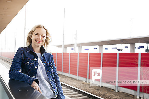 Smiling woman waiting at station platform