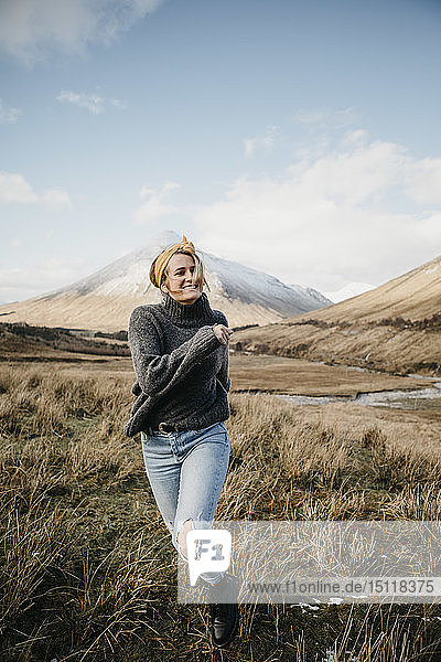 Großbritannien  Schottland  Loch Lomond und der Trossachs-Nationalpark  glückliche junge Frau läuft in ländlicher Landschaft