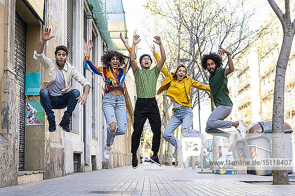 Fröhliche Gruppe von Freunden amüsiert sich in der Stadt beim Springen aus der Luft