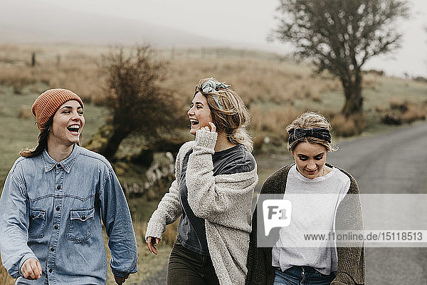 Großbritannien  Schottland  Isle of Skye  drei glückliche junge Frauen auf einer Landstraße