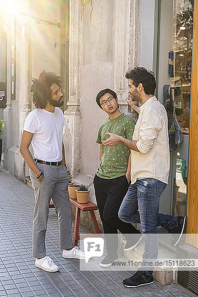 Drei junge Männer im Gespräch in der Stadt