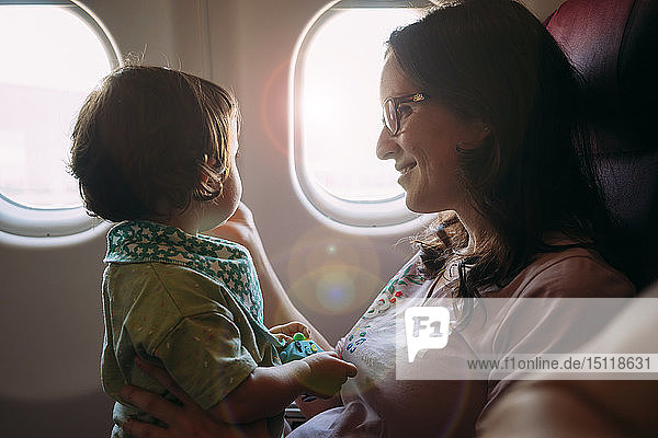 Glückliche Mutter und kleine Tochter im Flugzeug
