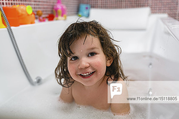 Porträt eines glücklichen kleinen Mädchens in der Badewanne