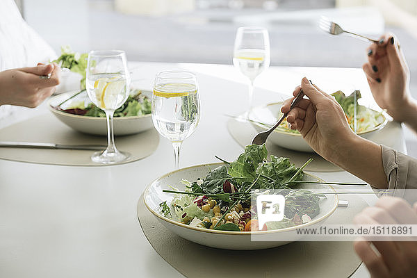 Nahaufnahme von drei Frauen  die in einem Restaurant Salat essen