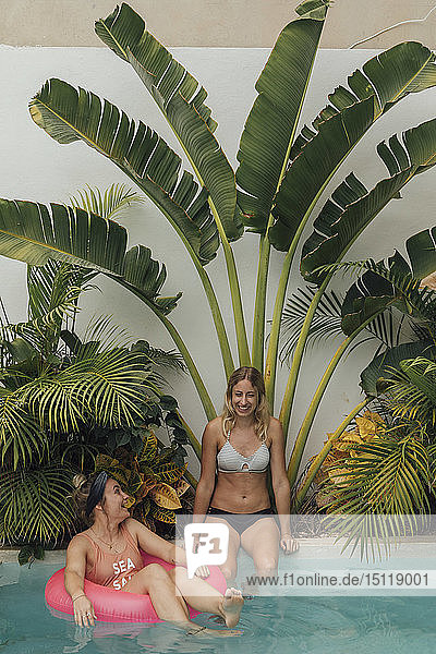 Zwei glückliche junge Frauen entspannen sich im Schwimmbad