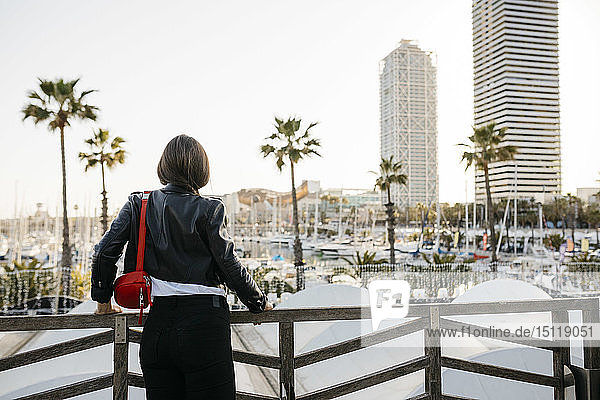 Spanien  Barcelona  Rückansicht einer jungen Frau mit Blick auf den Hafen