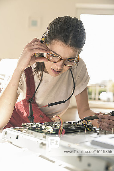 Junge Frau  die zu Hause an Computergeräten arbeitet
