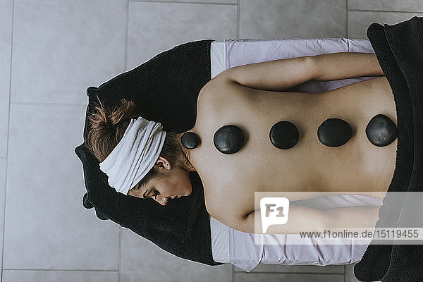 Young woman with heated stones on her back