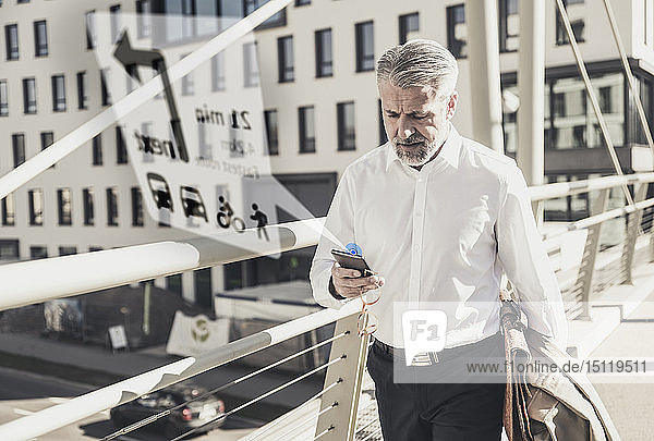 Älterer Geschäftsmann benutzt Mobiltelefon zur Navigation in der Stadt
