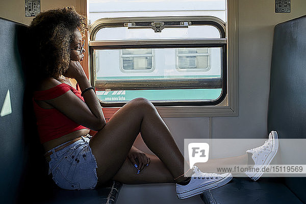 Junge Frau in einem Zug  die aus dem Fenster schaut