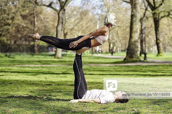 Junges Paar macht Yoga-Akrobatik in einem städtischen Park