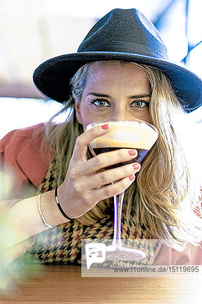 Frau trinkt einen Kaffee-Cocktail in einem Café