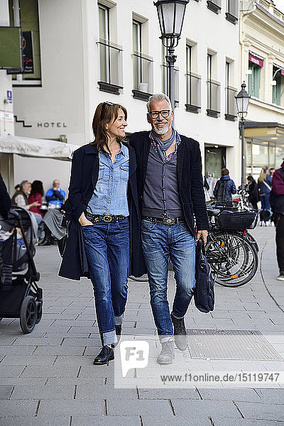 Mature couple walking in the city  with arms around