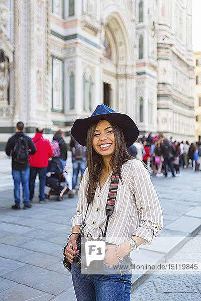 Italy  Florence  Piazza del Duomo  portrait of happy young tourist with camera