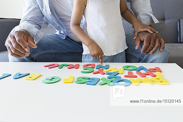 Nahaufnahme von Vater und Tochter beim Spielen mit Alphabet-Lernspiel zu Hause