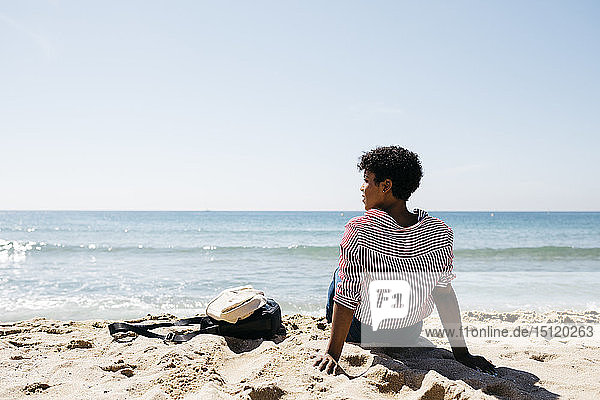 Woman sitting on the beach  enjoying the sun after work