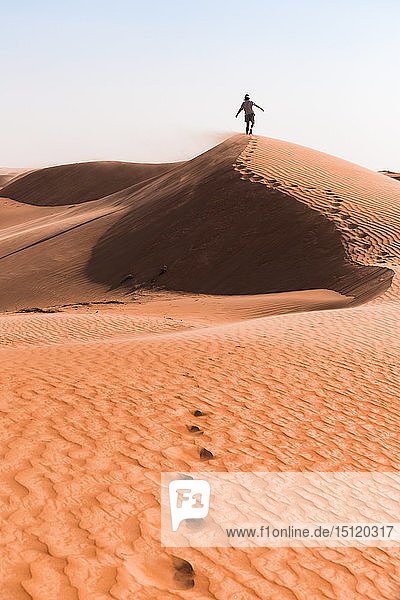 Auf einer Sanddüne gehender Mann  Wahiba Sands  Oman