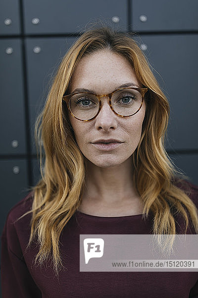 Porträt einer seriösen jungen Frau mit Brille