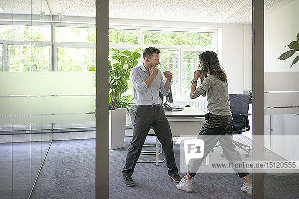 Businessman and businesswoman fighting in office