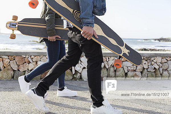 Junges Paar mit Longboards auf der Promenade  Teilansicht