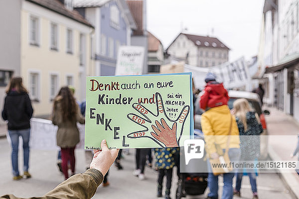 Hand hält ein Plakat auf einer Demonstration für Umweltschutz