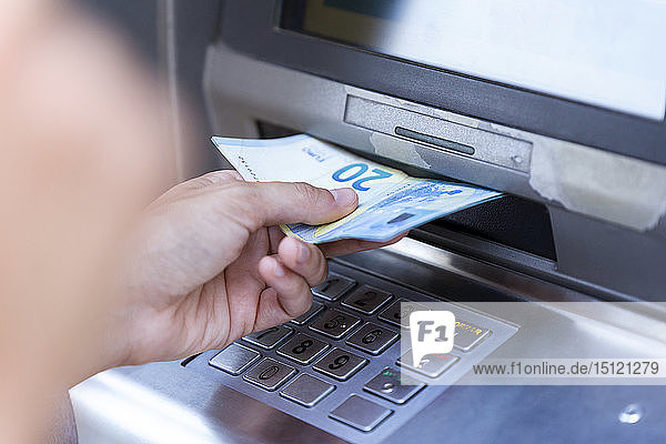 Nahaufnahme einer Geschäftsfrau  die an einem Geldautomaten Geld abhebt