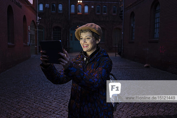 Germany  Berlin  portrait of happy tourist taking selfie with digital tablet