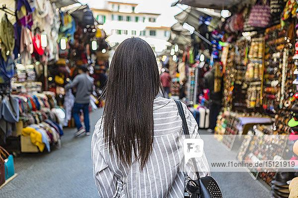 Italien  Florenz  Rückansicht eines jungen Touristen  der den Straßenmarkt erkundet