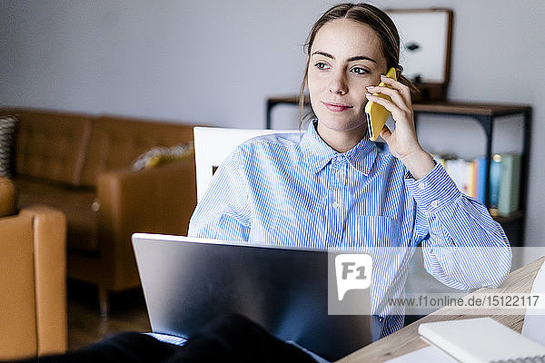 Porträt einer Frau im Büro am Mobiltelefon