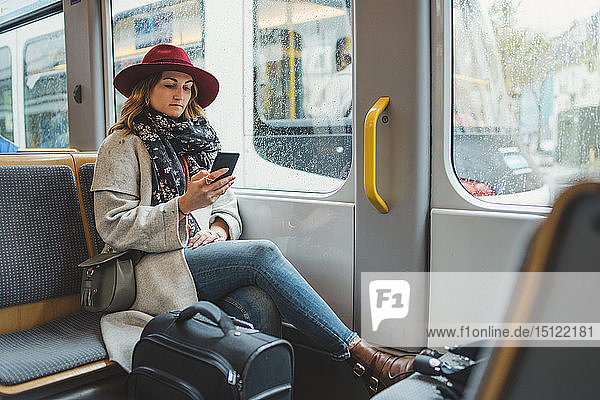 Young woman using cell phone in a tram
