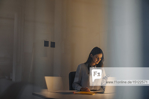 Young businesswoman working late at desk in office