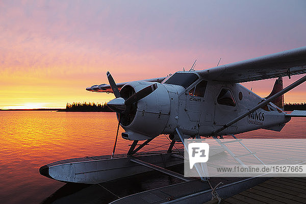 A float plane at the end of a jetty at sunrise in Egenolf Lake in northern Manitoba Canada North America