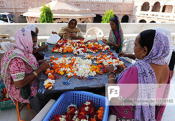 Frauen fädeln Mala (Girlanden) für die Diwali-Puja im kunstvollen Swaminarayan-Tempel aus weißem Marmor  Bhuj  Gujarat  Indien  Asien