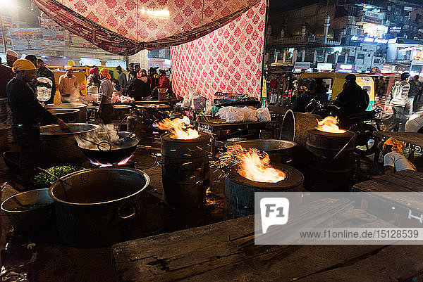 Flammende Gerichte auf der Straße  während Männer Essen für das Chandni Chowk Gudurwara vorbereiten  Delhi  Indien  Asien