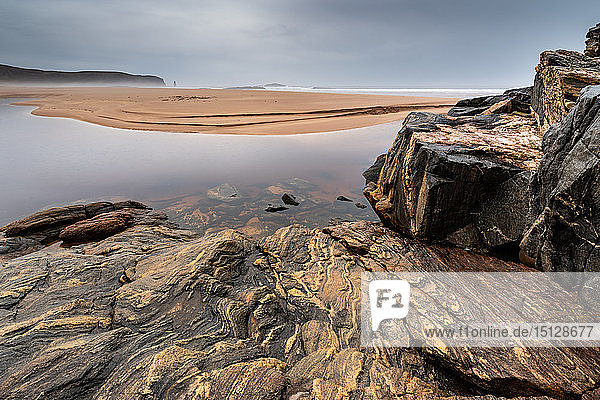 Felsformationen in der Sandwood Bay  mit Am Buachaille sea stack in weiter Ferne  Sutherland  Schottland  Vereinigtes Königreich  Europa