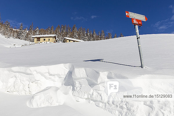 Traditionelle Hütten mit Trekkingsignal im Winter  Livigno  Valtellina  Lombardei  Italien  Europa