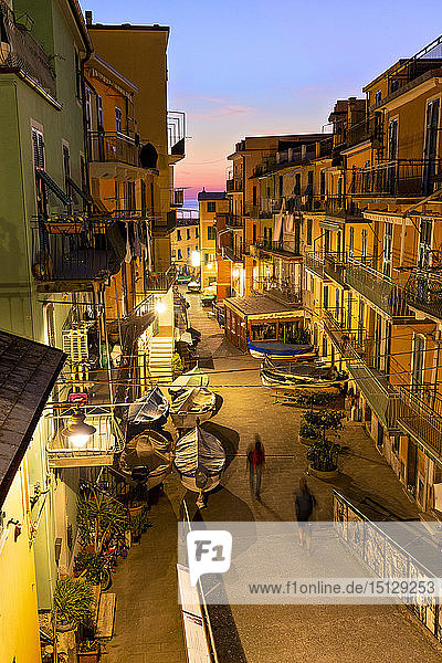Tourists walks in the main street of Manarola at dusk  Cinque Terre  UNESCO World Heritage Site  Liguria  Italy  Europe