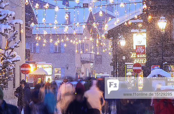 Busy street with tourists during snowfall Livigno Valtellina Lombardy Italy Europe
