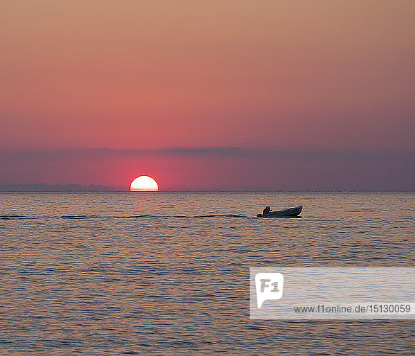 View across the Tyrrhenian Sea at sunrise  small boat crossing Calura Bay  Cefalu  Palermo  Sicily  Italy  Mediterranean  Europe