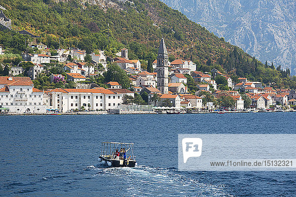 Small boat heading towards the waterfront across the Bay of Kotor  Perast  Kotor  UNESCO World Heritage Site  Montenegro  Europe