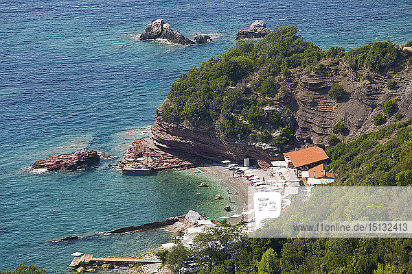 Blick von der Klippe über eine geschützte Bucht mit klarem türkisfarbenem Wasser  Sveti Stefan  Budva  Montenegro  Europa