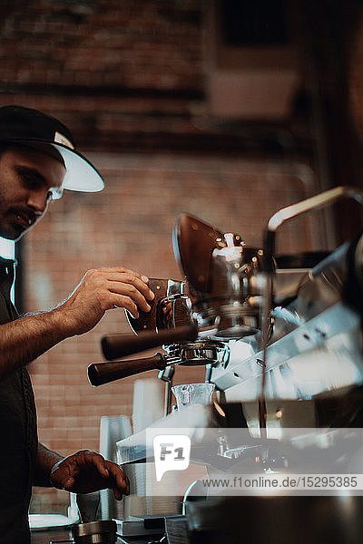 Barista mit Kaffeemaschine im Café  flache Seitenansicht