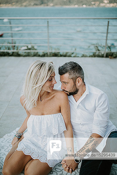 Romantisches Paar mittlerer Erwachsener  die sich gegenseitig am Seeufer anschauen  Stresa  Piemont  Italien
