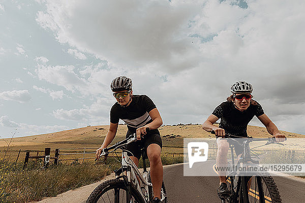 Young cycling couple cycling on rural road  Exeter  California  USA