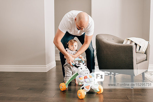 Father playing with baby daughter in living room  portrait