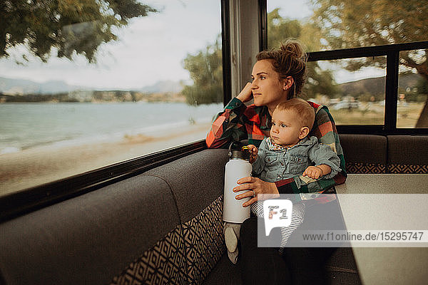 Mutter und Baby schauen aus dem Fenster eines Wohnmobils  Wanaka  Taranaki  Neuseeland