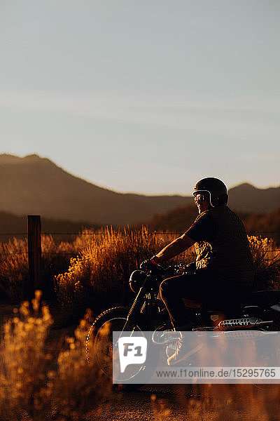 Motorbiker riding through landscape of Kennedy Meadows  California  US