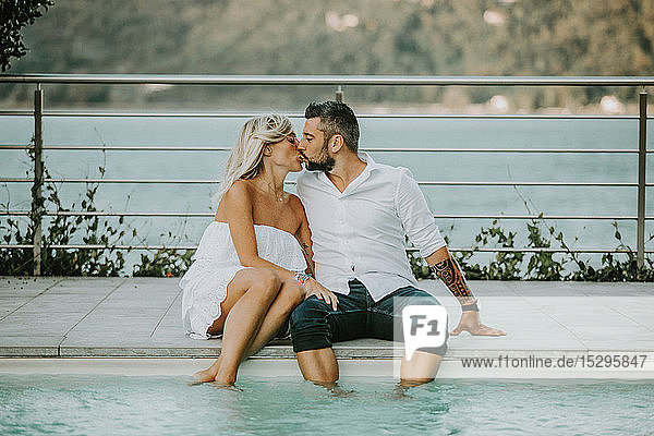 Romantisches Paar mittlerer Erwachsener  die sich am Pool küssen  Stresa  Piemont  Italien