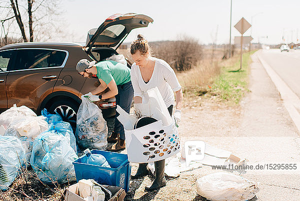 Ehepaar beim Aufsammeln von Müll am Straßenrand  Georgetown  Kanada
